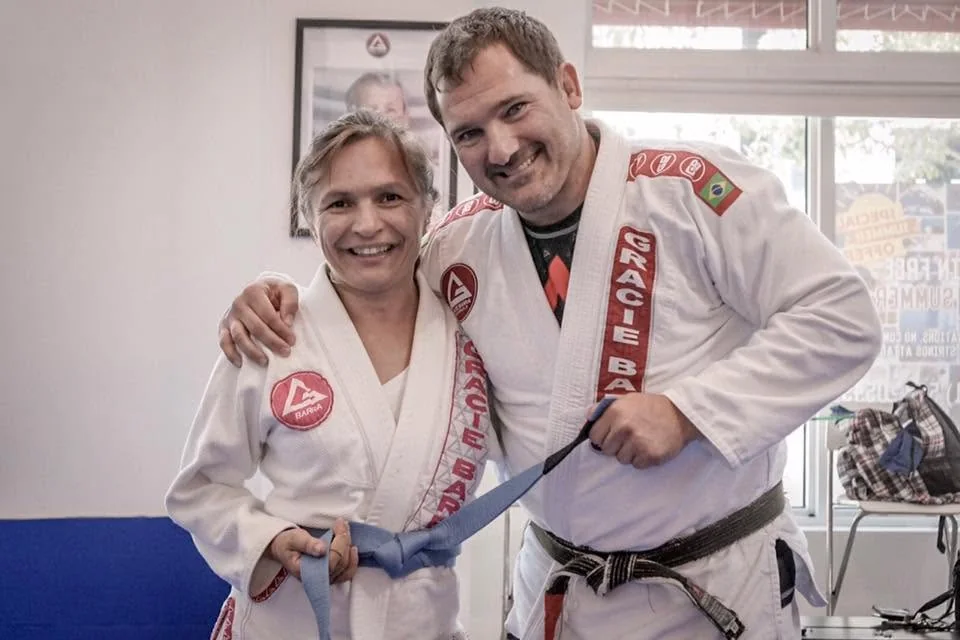 Coach Lil earning her Brazilian jiu-jitsu blue belt with her instructor