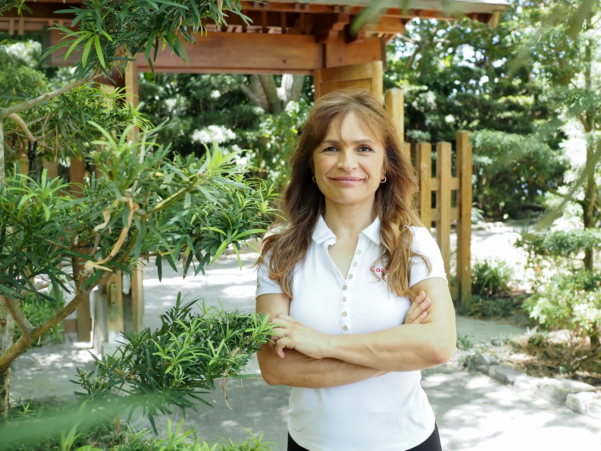 Coach Lil, personal trainer in Palm Beach, FL, by a garden gate